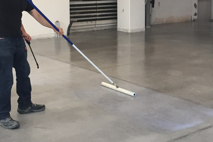 Applying GiGi Sealer to concrete floors with a special microfiber T-bar tool