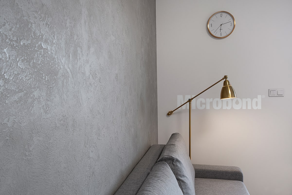 Living room wall covered with grey microcement with 3D texture