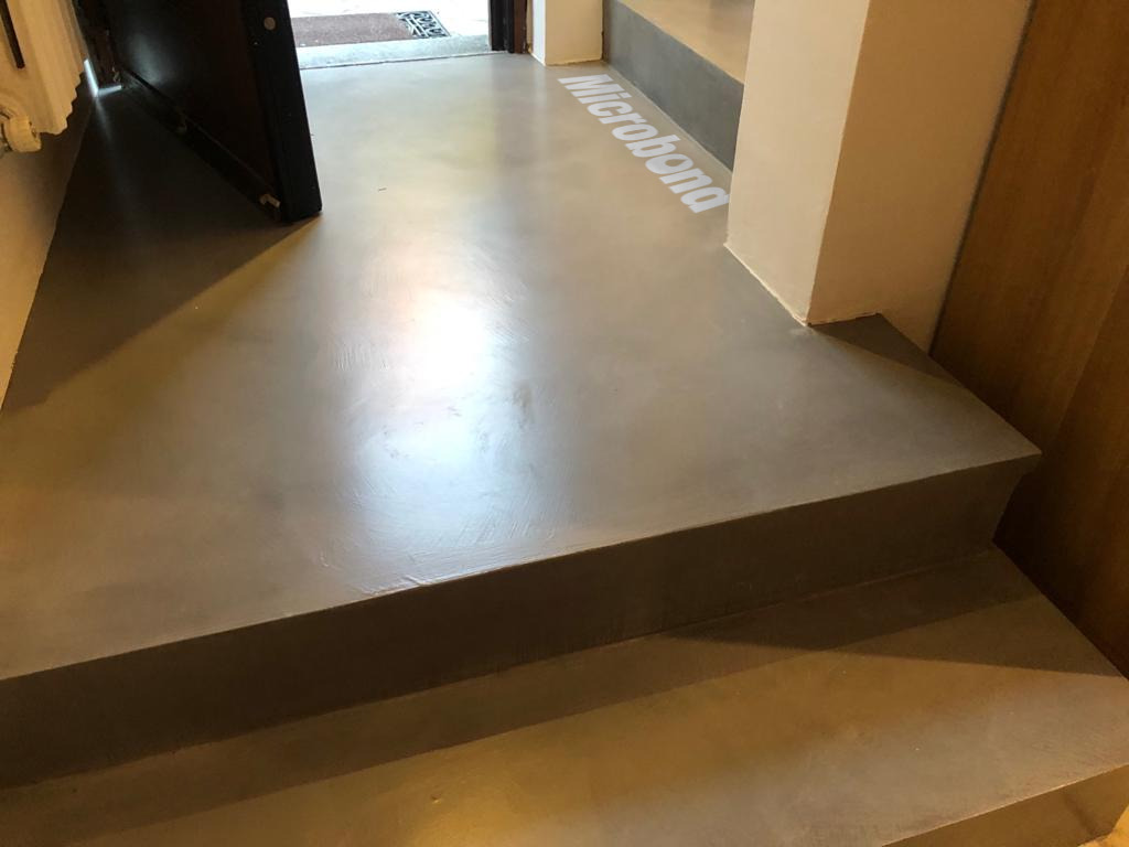 Steps overlayed in microcement in continuity with the entrance landing