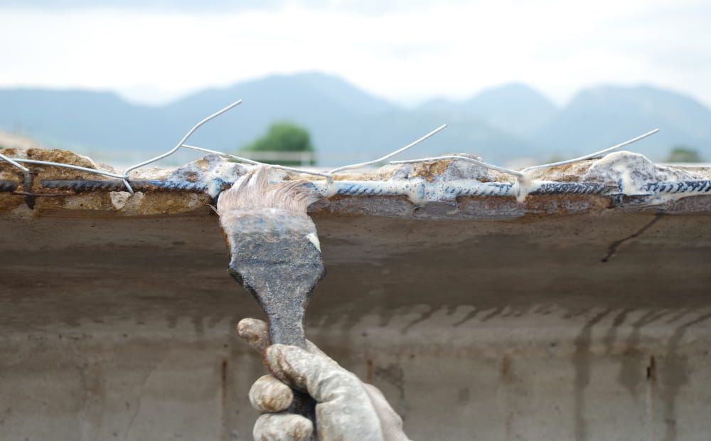 Application du convertisseur de rouille Rust Buster au pinceau sur les barres d'armature avant la réparation